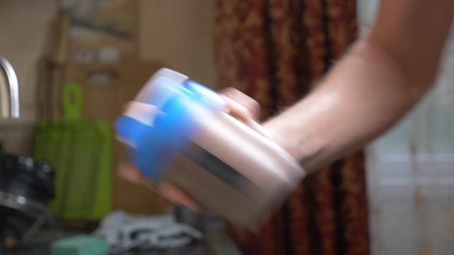 Slow motion. 4k. Young man making a protein shake at home. anonymously