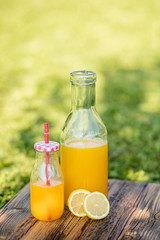 freshly sqeezed orange juice in a glass bottle outdoor shot in a garden