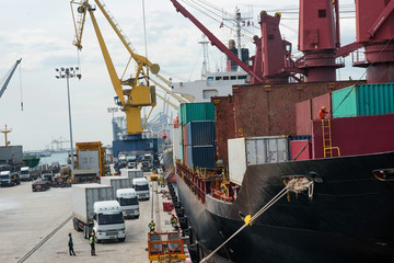 busy works in the port terminal by the vessel ship loaading and discharging operation to ensure the export and import economy are aim successfull in target of logistics transportation services