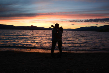 Couple kissing on sunset in front of the lake