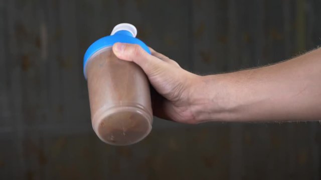 Slow motion. 4k. Young man making a protein shake at home. anonymously