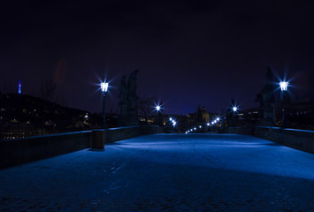 Winter night in Prague, the Charles Bridge covered with snow.