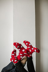 Feet in woollen socks. Pair relaxing with a cup of hot drink and warming up their feet in woollen socks. - 182910509