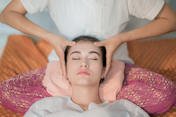 Fototapeta na wymiar Portrait of fresh and beautiful young Asian woman taking Thai head massage spa in spa salon.