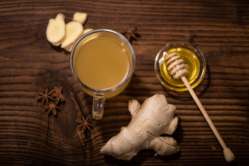 fresh ginger tea with honey on an old wood background