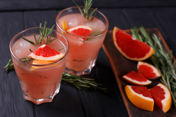 Delicious homemade refreshing grapefruit lemonade with ingredients on dark background, selective focus. Food background, recipe concept