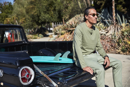 Man sitting on tailgate of pickup truck