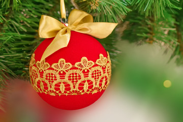 Christmas and New Year red ball with lace golden pattern on the Christmas tree. New Year's decoration.