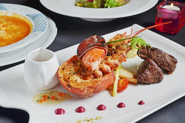 Grilled beef meat with lobster and sauce on white plate