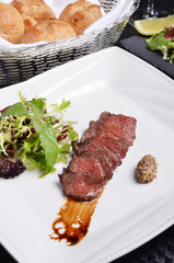 Grilled beef short ribs with salad on white plate 
