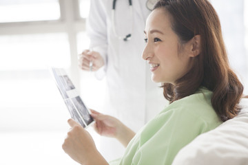 Mother looking at her echo pictures in bed