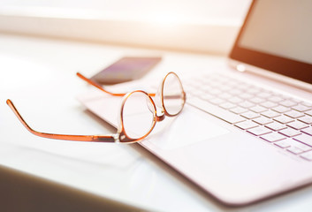 Desk with laptop, eye glasses,  and a cup of coffee. Concept of business