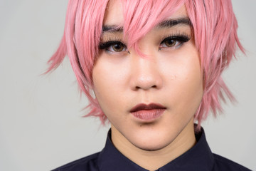 Portrait of androgynous young teenager transgender person wearing pink wig