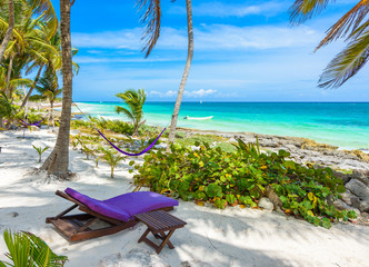 Obraz na płótnie Canvas Beach beds and Hammock under the palm trees on paradise beach at tropical Resort. Riviera Maya - Caribbean coast at Tulum in Quintana Roo, Mexico