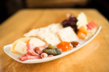 Side view on cheese and cracker with charcuterie on appetizer plate