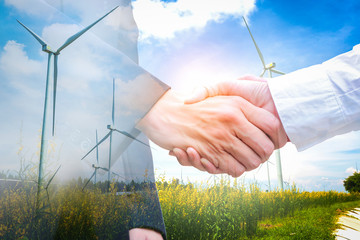 Double exposure of handshake with wind turbine. Ecology concept