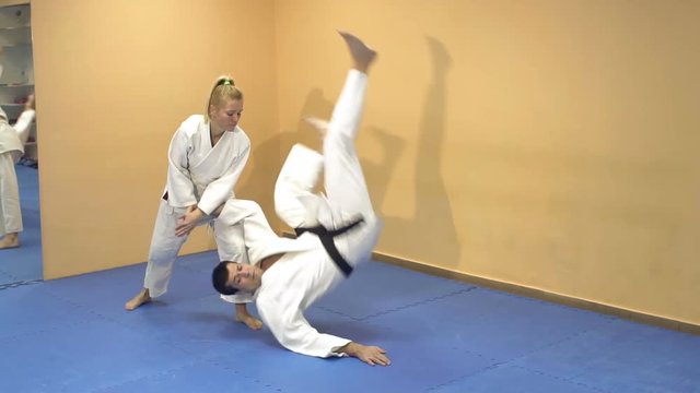 Man and woman demonstrate the technique Aikido school of martial arts, slow motion.