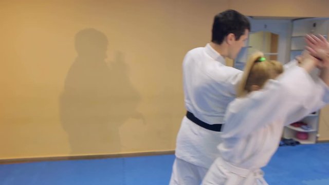Man and woman demonstrate the technique Aikido in school of martial arts.