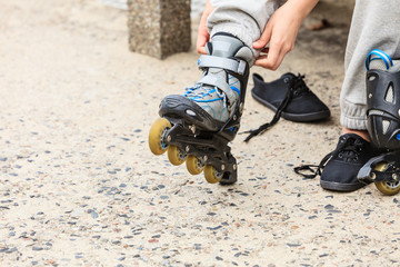 Woman putting on roller skates outdoor.