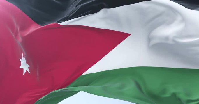 Flag of Jordan waving at wind with blue sky in slow, loop
