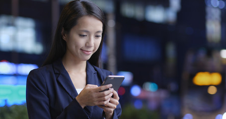 Businesswoman reply on cellphone in city at night