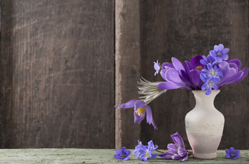 spring flowers in vase on wooden background