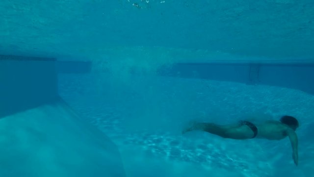 a man dive into the pool - underwater shot
