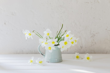 daffodils in jug on white background