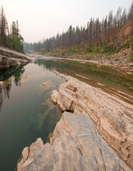 Deep Green Pool of still water in Meadow Creek Gorge in the Bob Marshall Wilderness area during the 2017 fall forest fires in Montana United States