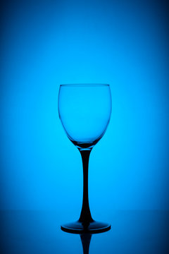 Empty wine glass on blue background