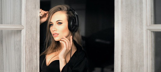 Fototapeta premium Closeup portrait of a young woman listening to music in headphones