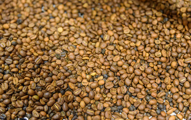 Coffee beans during the roasting process. Drum type roaster. Rosting process of coffee.