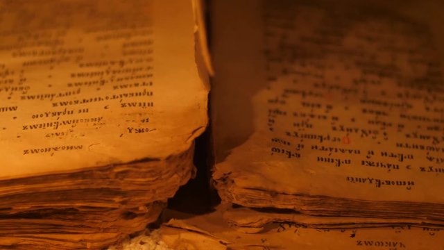 Elderly woman reading old book by candlelight

