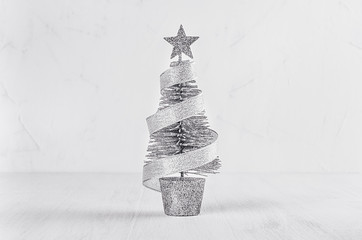 Silver christmas tree on white shabby plaster and wood background.