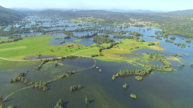 AERIAL: Flying over sunny autumn countryside after ravaging rainfall submerged majority of landscape. Roads, trees, fields all drowned underwater because of a catastrophic hurricane in Slovene karst.