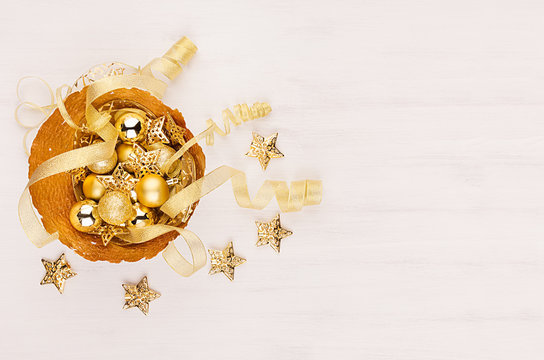 Christmas decorations of gold on white wood background. Top view.