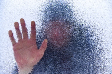 Silhouette of a man behind a frozen glass.Copy space.