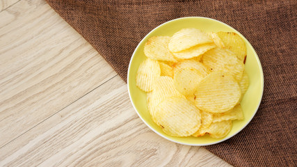 potatoes chips on a wooden table.