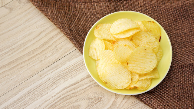 potatoes chips on a wooden table.