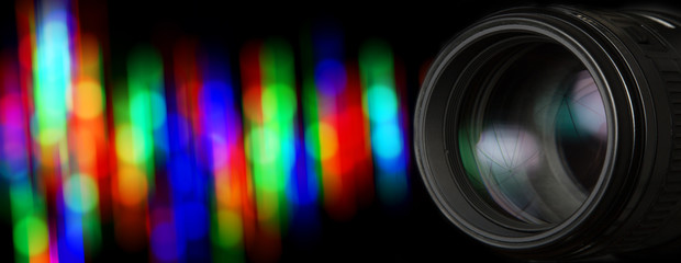 Photo lens and black background with individual light blur