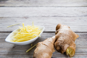 Ginger cut into strips on wooden table
