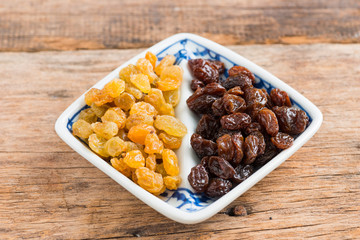 Raisins on a wood background.