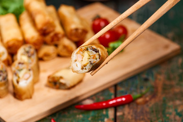 Vietnamese food. Delicious homemade spring rolls on wooden table.