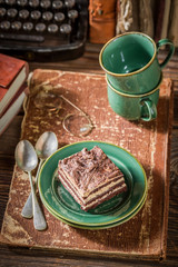 Tasty cake and coffee with books and typewriter