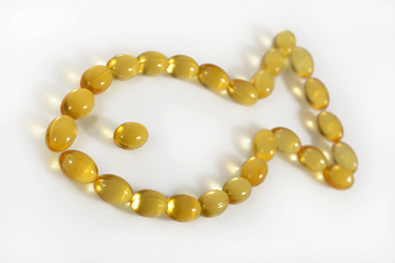 Omega-3 fish fat oil capsules shaped in fish on a white