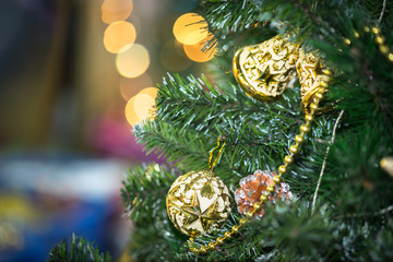 Decorations on christmas tree at night with bokeh on background, soft focus