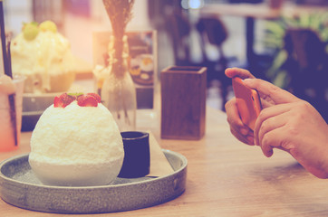 People using smartphones take photo sitting at the cafe comfortable