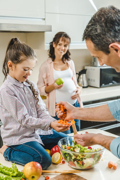 Happy Smiling Family Making Salad Together At Kitchen