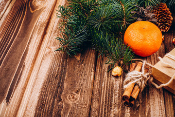 Little present box, species, tangerines and fir tree branch on a wooden table