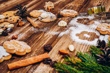 Delicious Christmas pastry, fir tree brances and cones on the wooden table